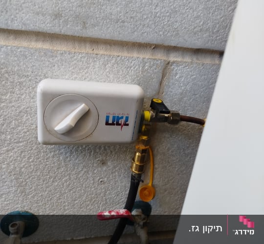 שסתום גז ומחברים על קיר בטון